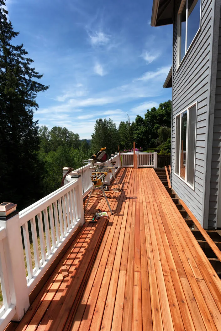 Deck with table saw on it as contractors cut and shape pine flooring boards