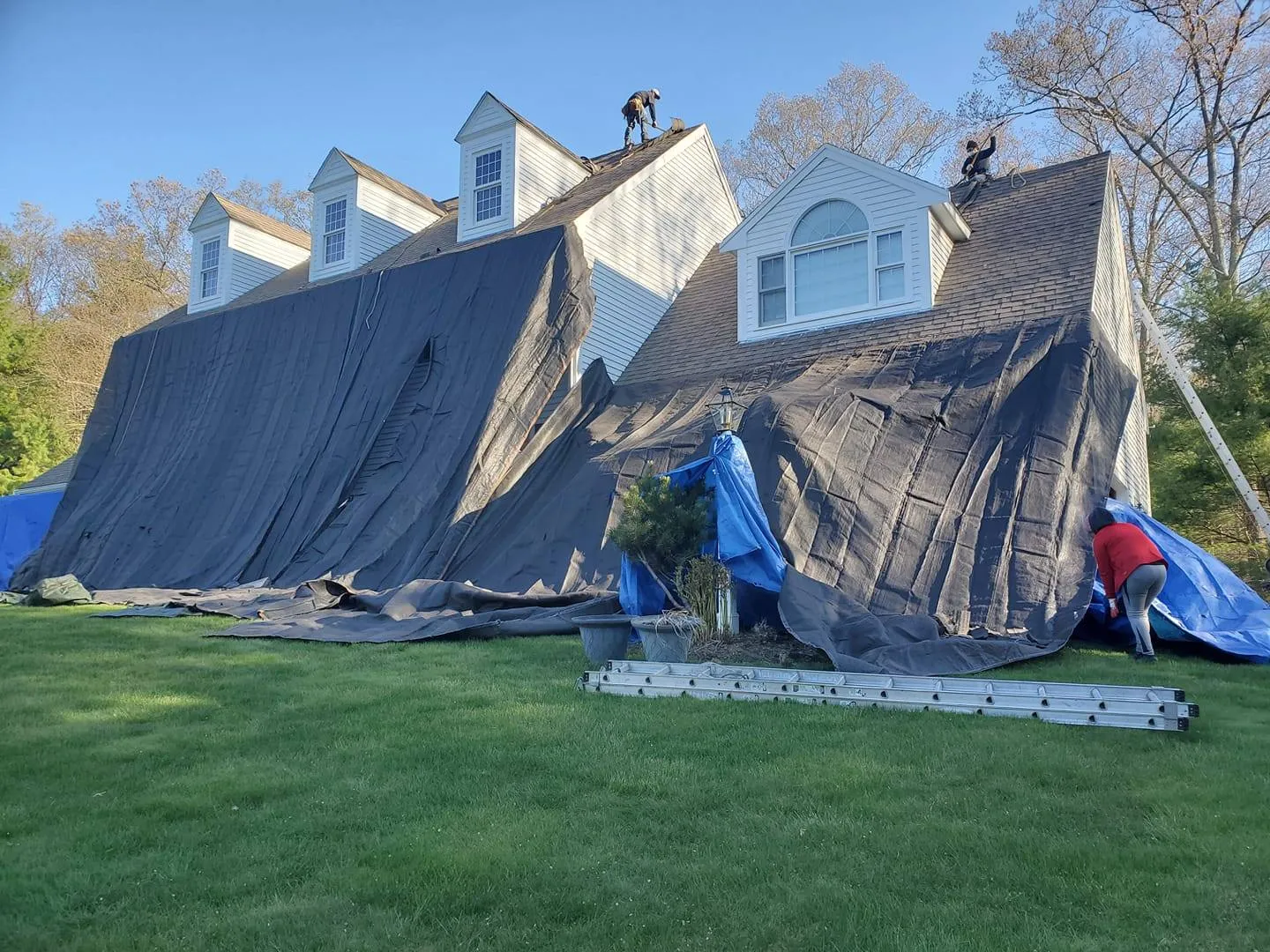 MBC Contracting Services Inc roof repair and installation in Rhode Island with men on the roof stripping the old roof off and preparing for new shingles